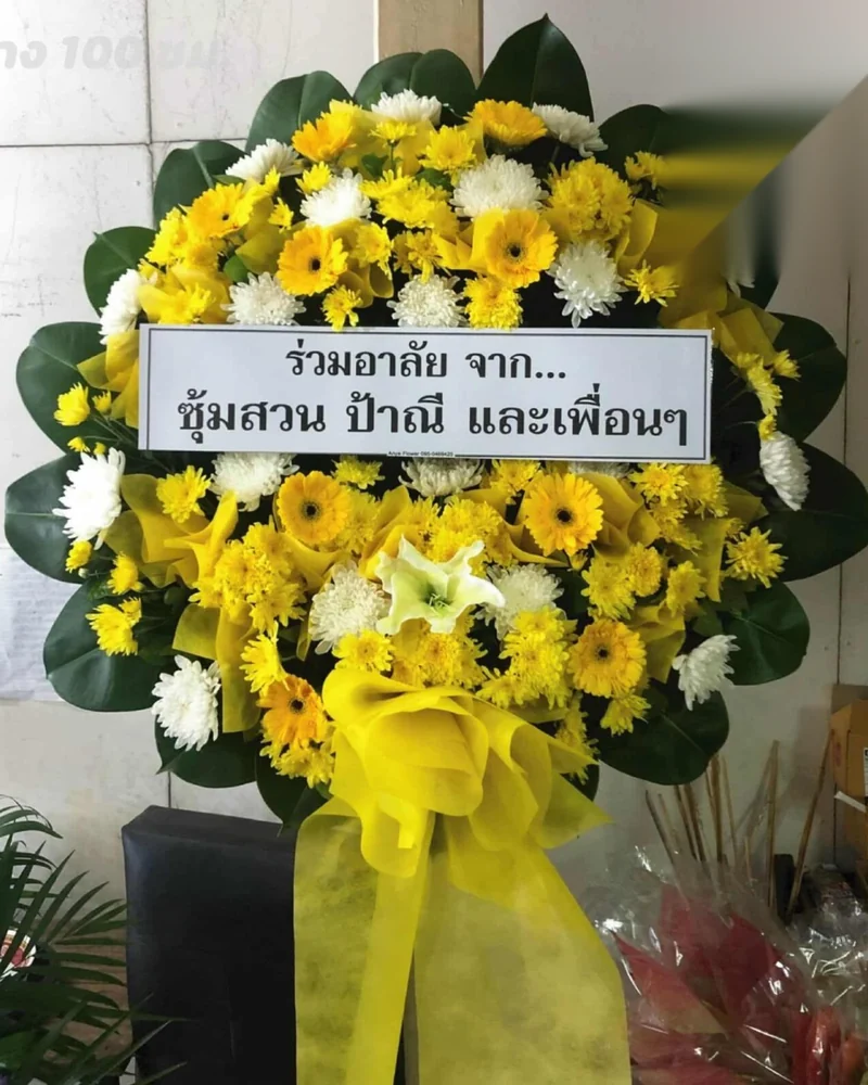 พวงหรีดทรงสูงป้ายชื่ออยู่ระดับสายตาเมื่อวางแถวหลัง