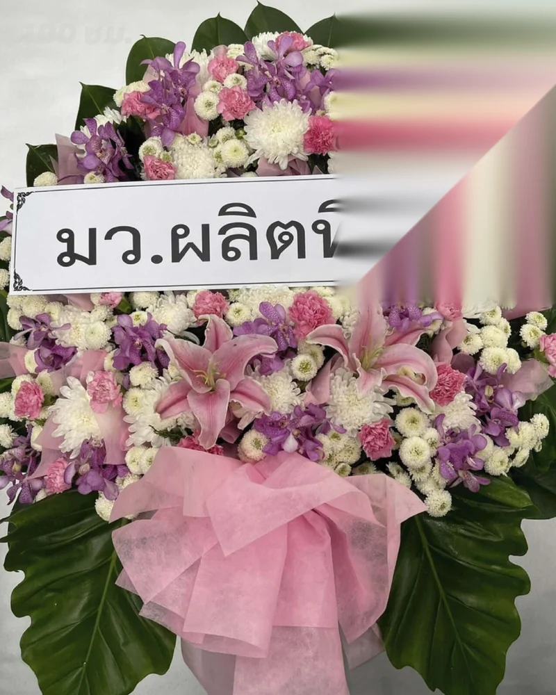พวงหรีดดอกไม้สดขนาดกลางบนขาตั้งเดี่ยวพร้อมป้ายชื่อผู้ส่ง