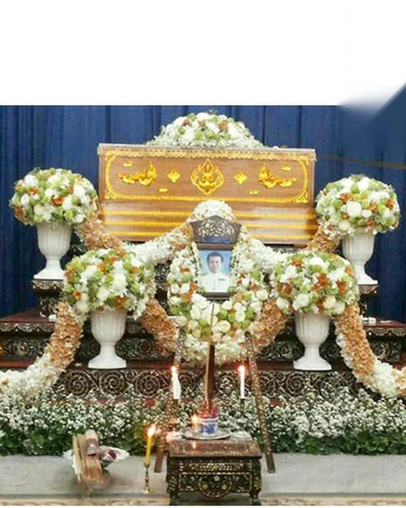 หีบศพและดอกไม้ประดับด้านหน้าที่จัดเสร็จเรียบร้อยภายในศาลาวัด
